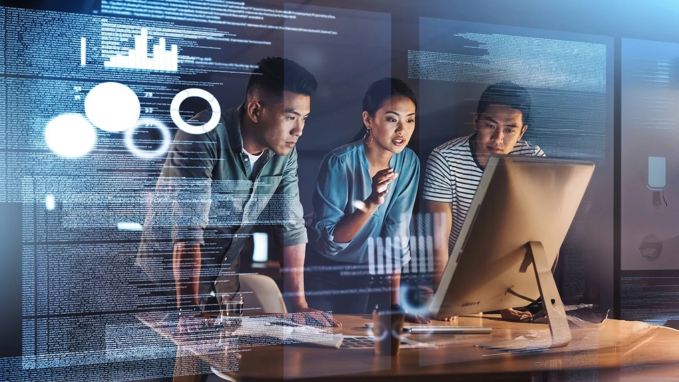 An Accordia team working together in front of a data display